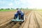 Farmer on a tractor making rows on a farm field. Preparing the land for planting future crop plants. Cultivation of soil for