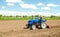 A farmer on a tractor with a mill unit crushes and processes the soil for further sowing with agricultural crops. Loosening