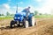 Farmer on a tractor with milling machine loosens, grinds and mixes soil. Loosening the surface, cultivating the land for further