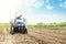 Farmer on a tractor with milling machine loosens, grinds and mixes soil. Loosening the surface, cultivating the land for further