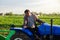 A farmer on a tractor monitors the operation of equipment for harvesting potatoes. Farming and farmland. Simplify speed up work