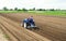 A farmer on a tractor plows the field for further sowing of the crop. Soil preparation. Working with a plow. Growing vegetables
