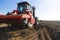 A farmer on a tractor prepares land to begin planting.