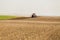 Farmer in tractor preparing land with seedbed cultivator as part of pre seeding activities in early spring season of agricultural