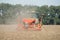 Farmer with tractor with seeder, sowing seeding crops at agricultural field