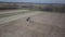 A farmer on a tractor with a seeder sows grain in plowed land in a private field in the village area. Mechanization of spring fiel