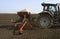 Farmer with tractor seeding crops at field