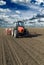 Farmer in tractor sowing corn maize crops.