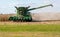 A farmer turning his John Deere combine harvester