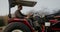 A farmer turns a tractor, moving to a new lane while plowing a field