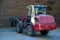 Farmer unloading round bales of straw with a front end loader