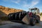 Farmer unloading round bales of straw with a front end loader