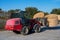 Farmer unloading round bales of straw with a front end loader