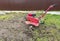 a farmer uses a red-colored technique to cultivate a small plot of land. plows, cultivates the land