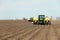 A farmer uses a tractor and a planter to plant potatoes in Idaho.