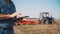 farmer is using digital tablet. close-up. on farm field, near tractor, on farm machinery backdrop. smart farming