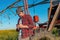 Farmer using mobile smart phone next to the center pivot irrigation equipment in rapeseed field