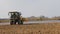 Farmer using a self propelled crop sprayer in a field in early spring.