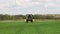 Farmer using a self propelled crop sprayer in a field in early spring.