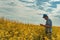 Farmer using smart phone in blooming canola field