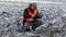 Farmer using tablet PC on plowed,frozen field with snow in winter