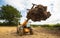 Farmer using a telehandler with a muck fork full of manure. UK