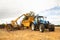 Farmer using a telehandler to load manure into a muck spreader.