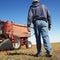 Farmer walking toward combine.