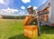 Farmer wearing bee suit working with honeycomb