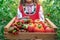 Farmer woman, bulgarian girl in traditional Bulgarian folklore dress holding wooden basket crate full of fresh raw homegrown