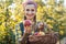 Farmer woman in fruit orchard holding apple in her hands offering