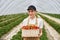 Farmer woman holding wicker basket with tasty strawberries.