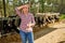 Farmer woman rancher holding her head has problems on farm with dairy cows