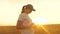 Farmer woman in wheat field at sunset. Organic grain on plantation. Agronomist woman farmer, business woman looks into a