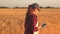 Farmer woman working with tablet on wheat field. agronomist with tablet studying wheat harvest in the field. business