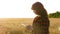 Farmer women works with a tablet in a wheat field, plans a grain crop. business woman plans her income in a wheat field