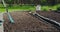 Farmer working in garden, loosening soil with rake for planting. Landscaping, farming, gardening concept