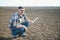 The farmer works on the ground. Male farmer on a plowed field, planting cereals in the spring in the ground