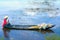 Farmers carrying lilies boating through rural marshland in early morning