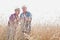 Farmers examining wheat grains in field