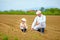 Farmers, family on their land, checking plant growth