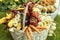 Farmers hand holding a basket with seasonal products, wooden basket full with autumnal products, agricultural and forest also