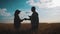 Farmers handshake over the wheat crop in harvest time. Team farmers stand in a wheat field with tablet. Partnership