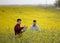 Farmers with laptop in rapessed field