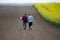 Farmers with laptop in rapessed field