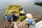 Farmers are loading harvested rice from floating boat up to transport vehicle next to the lake