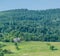 Farmhouse, field and hilly forest