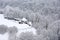 Farmhouse on a hill in the forest after snowfall, rural scene