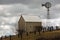 Farmhouse and Windmill on a Cloudy Day