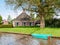 Farmhouse with wooden shutters by Dokkumer Ee canal in Burdaard, Friesland, Netherlands